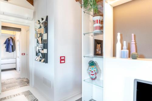 een hal met witte muren en planken met een masker bij PgrHome Coral Loft Venice in Venetië