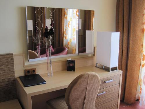 a desk with a mirror and a chair in a room at Hotel Attersee in Seewalchen