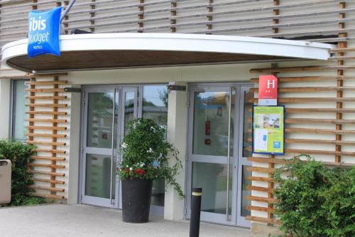 a bus stop with a bus stop sign in front of a building at ibis budget Metz Technopole in Metz