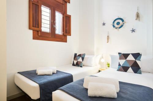 バルセロナにあるUma Suites Barceloneta Beachのベッド2台と窓が備わる客室です。