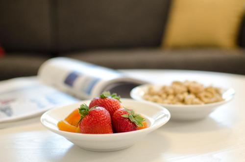 two bowls of strawberries and cereal on a table at Holiday Club Åre Apartments in Åre