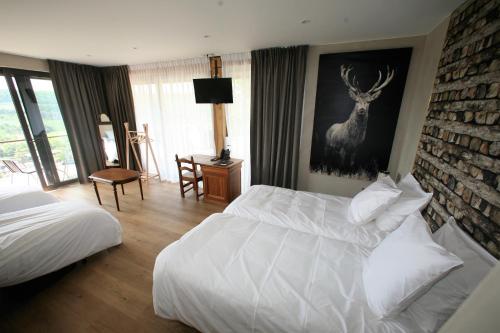 a bedroom with a bed and a deer painting on the wall at La Fête au Palais in Lustin