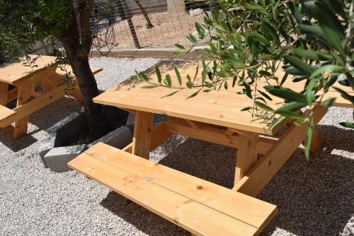 a wooden picnic table and bench next to a tree at Khan Alsira - חאן אלסרה in Alsira