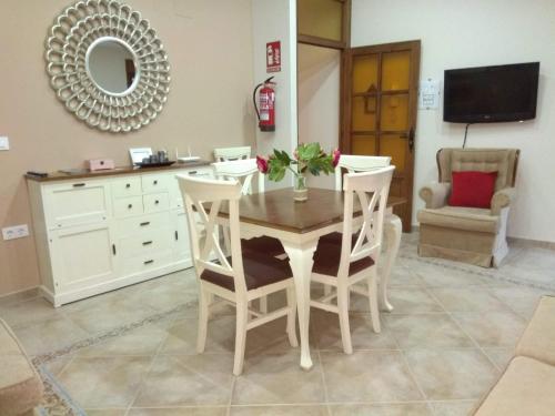 comedor con mesa, sillas y espejo en Apartamentos Rurales Tía María en Mata de Alcántara