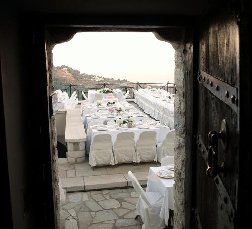 a row of tables with white linen and chairs at Archontika Karamarlis in Makrinítsa