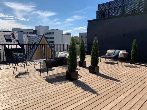 a balcony with chairs and potted trees on a building at Thomas' Home - Trendy, Central & Balcony in Tallinn
