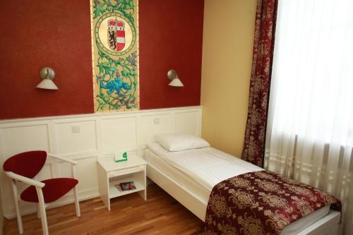 a small bedroom with a small bed and a chair at Fontush Boutique Hotel in Ivano-Frankivsʼk