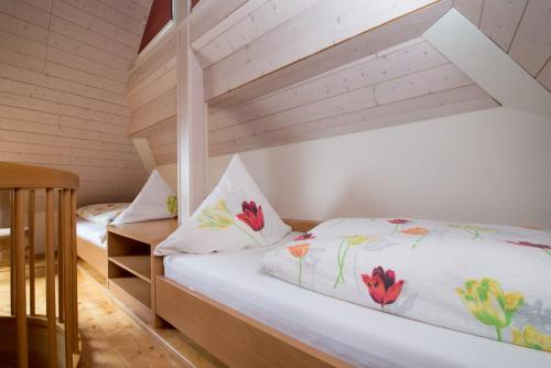 1 dormitorio con 2 camas con sábanas blancas y flores en Riehle Hof, en Zell am Harmersbach