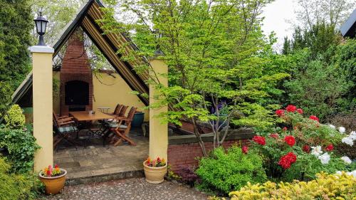 a patio with a table and chairs in a garden at Willa Reglówka Stylowy dom Pachnący ogród in Wola Krakowiańska