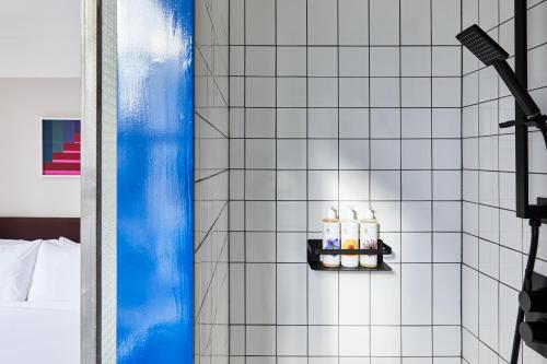 a bathroom with a shower with three bottles of toiletries at The Buxton in London