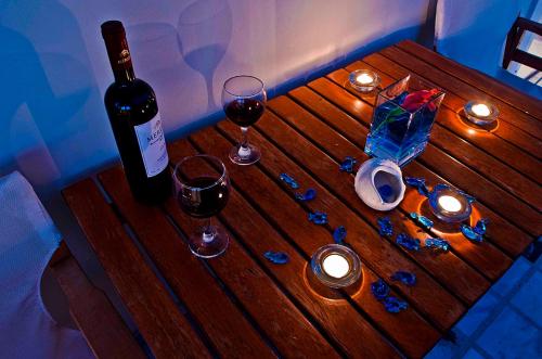 a wooden table with two glasses of wine and candles at Sea Breeze in Kalamaki Chanion