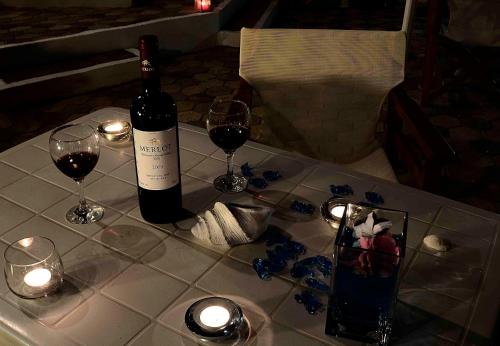 a bottle of wine and two glasses on a table at Sea Breeze in Kalamaki Chanion