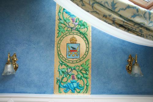 a blue wall with a painting on it at Fontush Boutique Hotel in Ivano-Frankivsʼk