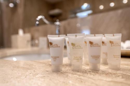 four tubes of sunscreen sitting on a counter in a bathroom at Hotel Pušų paunksnėje in Palanga