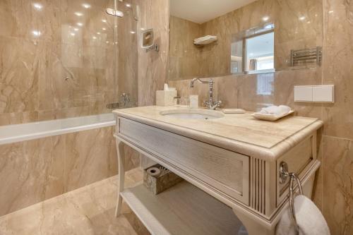 a bathroom with a sink and a shower at Hotel Pušų paunksnėje in Palanga