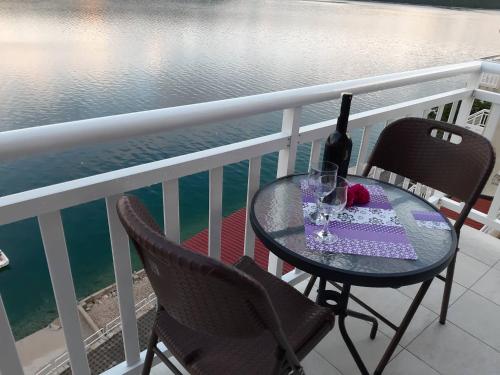 a table and two chairs on a balcony with the water at Apartments Leža in Neum