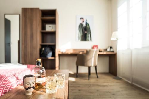 einen Tisch mit einer Flasche Wein und Gläsern darauf in der Unterkunft Kunsthotel "Drei König" am Marktplatz Stadt Lörrach in Lörrach