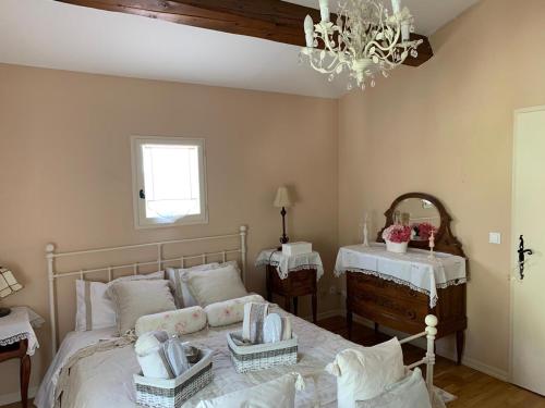 a bedroom with a bed with two tables and a chandelier at Villa Magnolia in Seillans