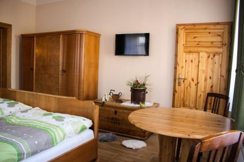 una camera da letto con tavolo, letto e armadietto in legno di Bauernhof Gerth a Göllnitz