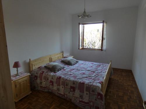 a bedroom with a bed and a window at Baita Figliezzi in Castello Tesino