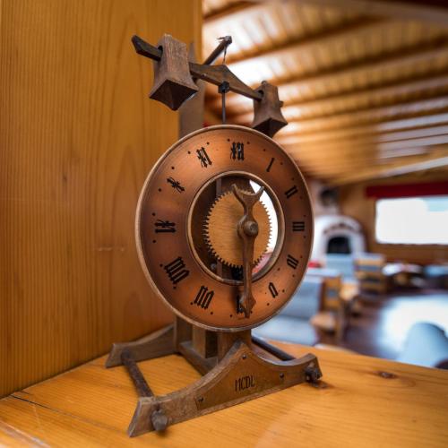 a clock sitting on top of a wooden table at Hotel Valgranda Wellness & Spa in Val di Zoldo