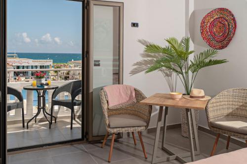 a room with a balcony with a table and chairs at Sonio Beach - Que Bella Collection in Plataniás