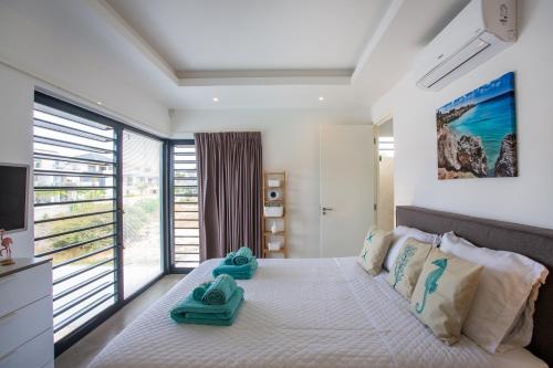 1 dormitorio con 1 cama con toallas en La Royal Penthouse Apartment Jan Thiel, en Jan Thiel
