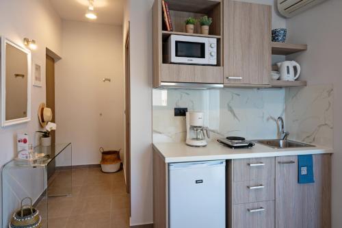 a small kitchen with a sink and a microwave at Sonio Beach - Que Bella Collection in Plataniás
