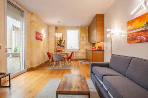 un salon avec un canapé et une table dans l'établissement Appart Hypercentre - Le Dijeaux, à Bordeaux