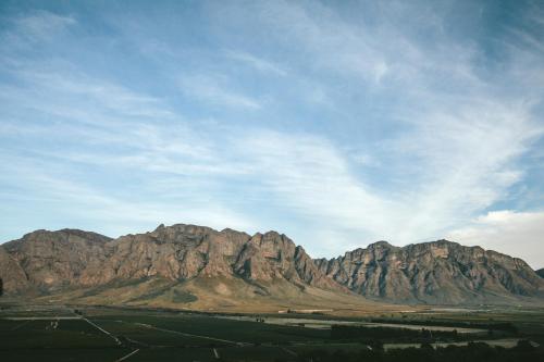 a group of mountains under a cloudy blue sky at Opstal Stay in Rawsonville