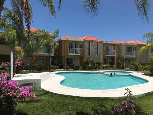 a swimming pool in front of a house at Punta Cana Apartment and scooter for free in Punta Cana