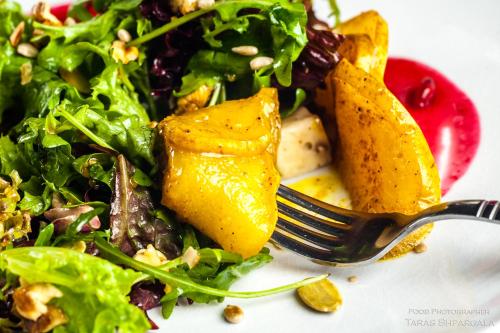a plate of food with a salad and a fork at Fontush Boutique Hotel in Ivano-Frankivsʼk