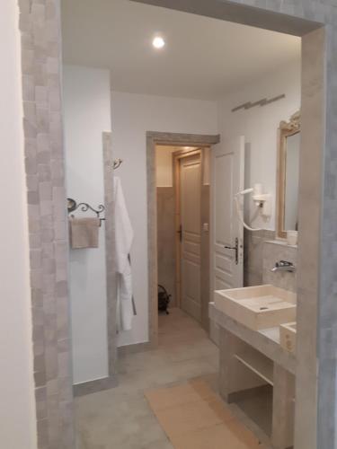 La salle de bains est pourvue d'un lavabo et d'un miroir. dans l'établissement VILLA LA LICORNE Piscine privée, Jacuzzi, Massages, Tennis, Golf à 11km, à Belcodène