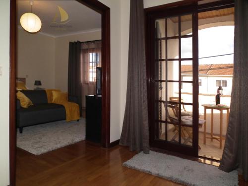 a living room with a sliding glass door with a couch at Areias do Douro GuestHouse in Gondomar