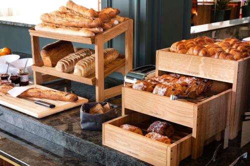 uma padaria com diferentes tipos de pães e pastelarias em Hotel Le Pavillon 7 em Obernai