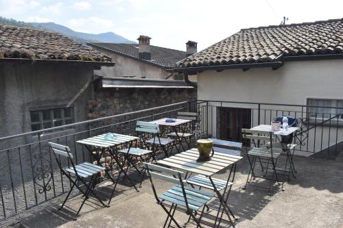 a patio with tables and chairs on a balcony at Casa Angiolina - Holidays - Appartamento Dolce Letargo in Morcote