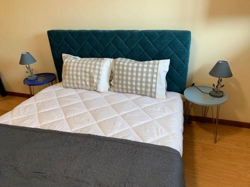 a bedroom with a bed with a blue headboard and two tables at Invicta House Loft Boavista in Porto