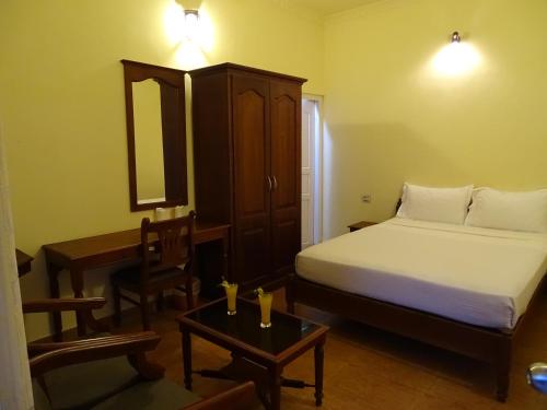 a bedroom with a bed and a table and a mirror at Sealine Beach Resorts in Cherai Beach
