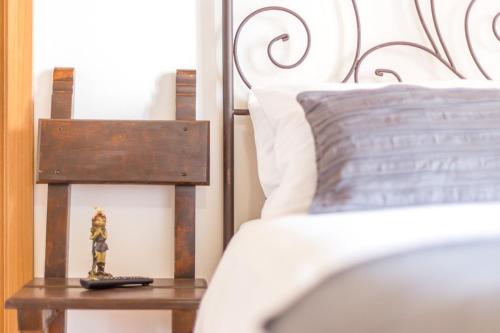 a small figurine on a table next to a bed at Guest House Casa del Folletto in Stresa