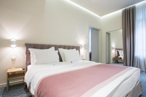 a bedroom with a large bed and a large window at Jump INN Hotel Belgrade in Belgrade