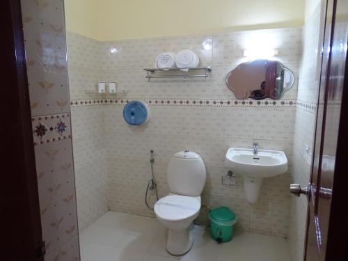 a small bathroom with a toilet and a sink at Sealine Beach Resorts in Cherai Beach