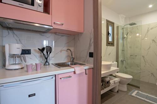 eine rosa Küche mit einem Waschbecken und einem WC in der Unterkunft Sonio Beach - Que Bella Collection in Platanias