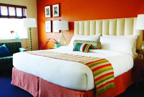 ein großes weißes Bett in einem Zimmer mit orangefarbenen Wänden in der Unterkunft Hotel Del Sol in San Francisco