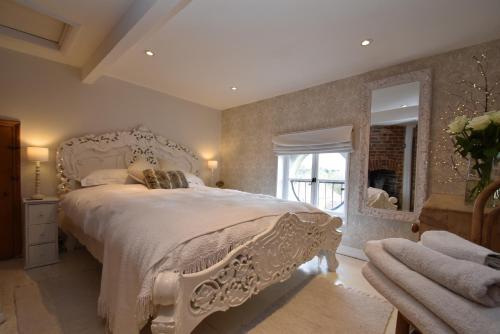 een slaapkamer met een wit bed en een spiegel bij Little Turret in St. Leonards