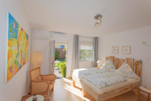 a bedroom with a bed and a chair at Alte Schmiede Putbus in Putbus