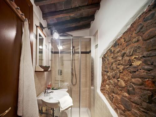 baño con lavabo y pared de piedra en One of a kind Near The Duomo w/Balcony Palace Apt, en Florencia