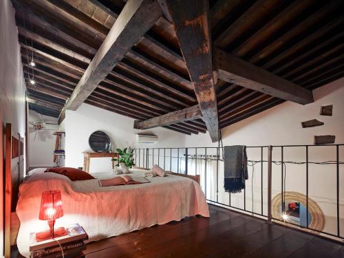 佛羅倫斯的住宿－One of a kind Near The Duomo w/Balcony Palace Apt，一间卧室设有一张大床和木制天花板。