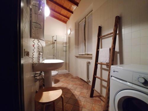 a bathroom with a sink and a washing machine at Appartamenti I Cortivi in Costermano