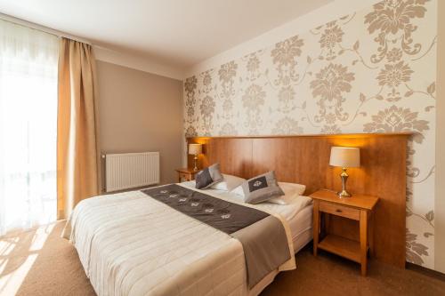 een hotelkamer met een bed en een raam bij Pensjonat Zenit in Ustronie Morskie