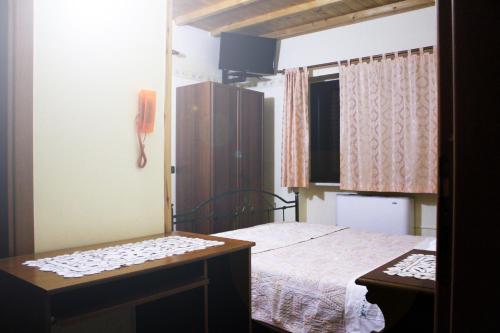 Dormitorio pequeño con cama y mesa en La Fattoria en Cusano Mutri